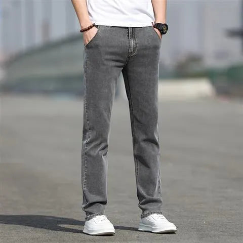 Man wearing smoky grey straight leg men's jeans with a low waist and zip fly.
