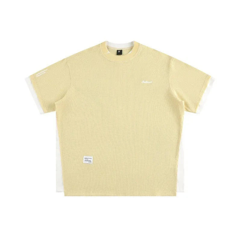 Loose grey waffle-textured t-shirt with embroidered retro lettering on the chest.
