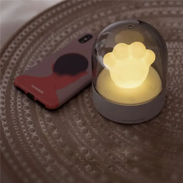 Grey and pink cat paw shaped USB rechargeable night light with adjustable brightness and musical rotation features