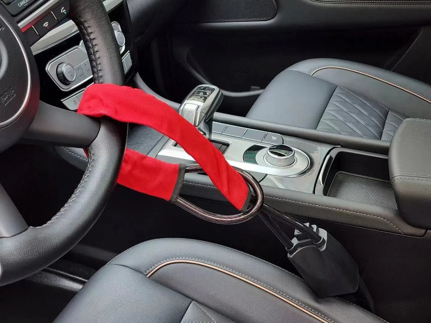 Red iron steering wheel lock with wire rope for a General Motors car.