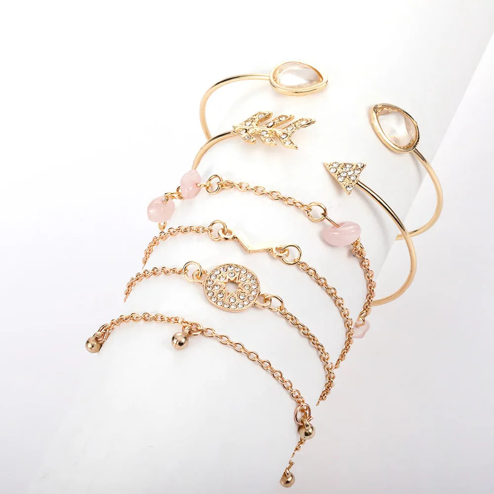 Gold-coloured six-piece women's bracelet set with arrow, water drop, and V-shaped charms on a white background.