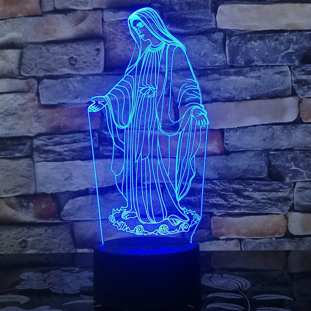 3D LED night light with colourful dual-ring pattern, remote control, and USB cable on a desk.