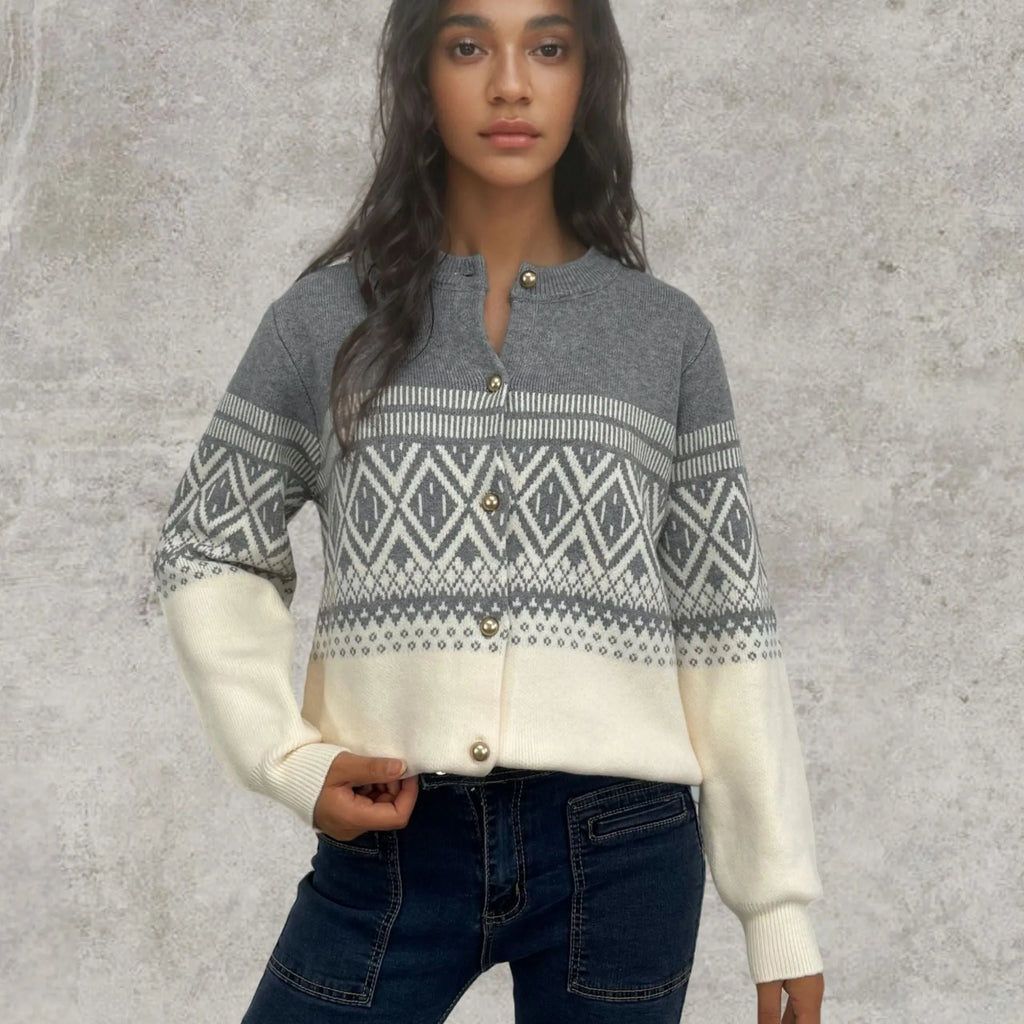Woman wearing a grey alpaca wool cardigan with a long sleeve diamond pattern in a contrast colour.