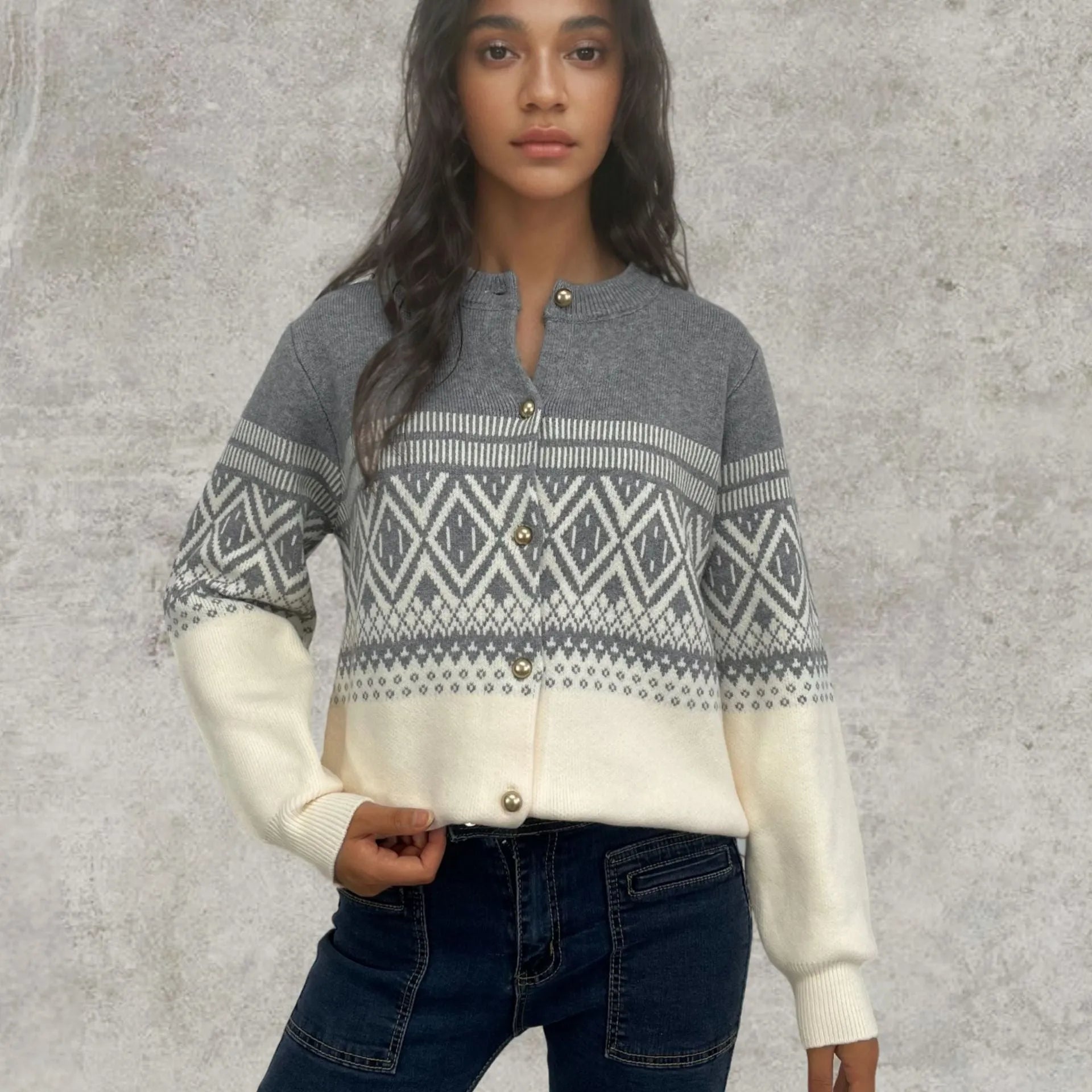 Woman wearing a grey alpaca wool cardigan with a long sleeve diamond pattern in a contrast colour.