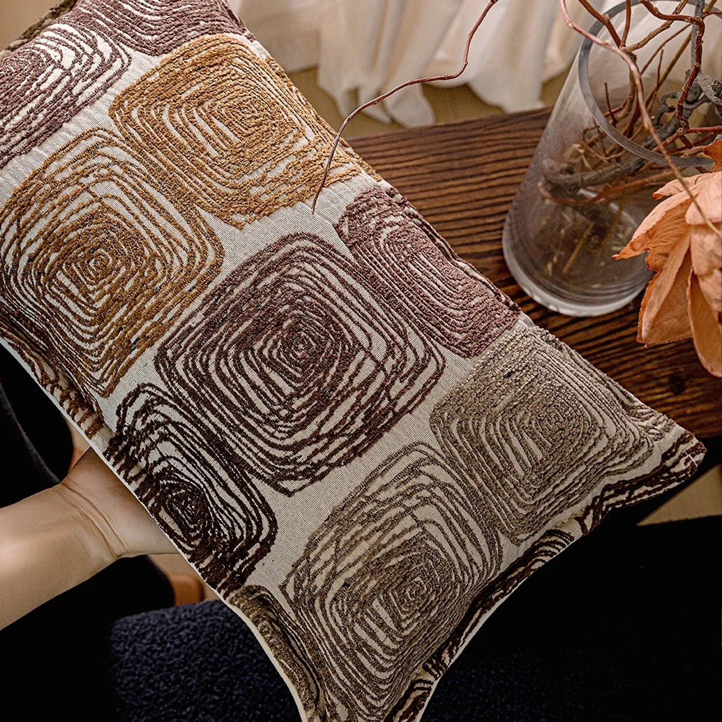 Abstract geometric coil pattern pillow cover in cream and coffee colours on textured fabric