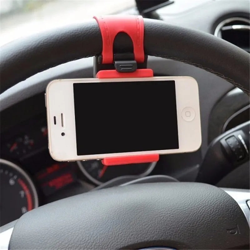 Black steering wheel phone holder clip mounted on car steering wheel holding a smartphone