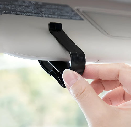 Black plastic clip for holding glasses and cards on a car sun visor.