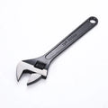 Stainless steel adjustable open-end wrench with blackened finish showing adjustment mechanism and four size options
