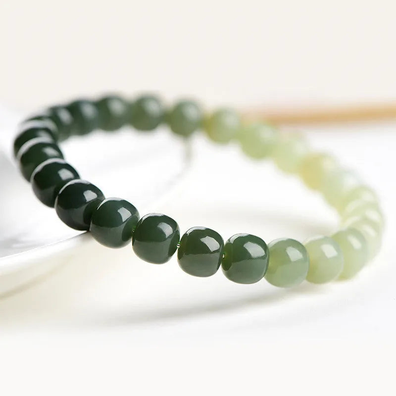 Natural Hetian Jade bracelet showing water gradient colour on wrist, with polished beads.