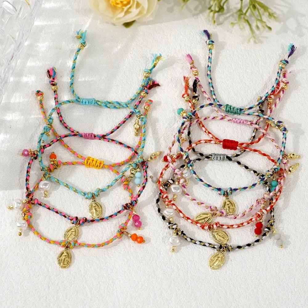 Close-up of a woman's hand-woven colourful braided rope bracelet with an adjustable strap tag.