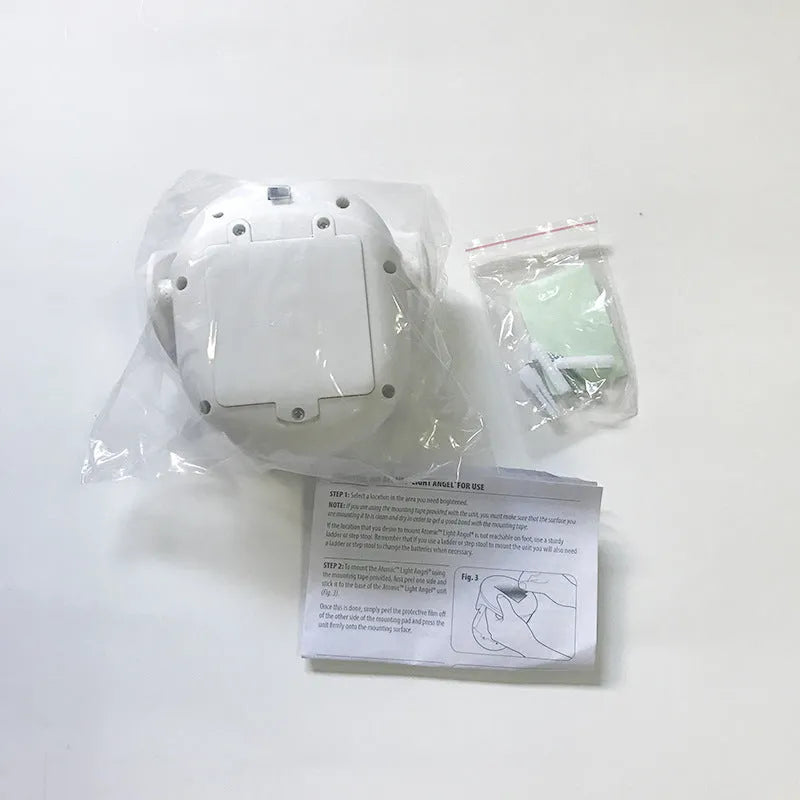 White Atomic Angel induction-activated LED night light on a surface.