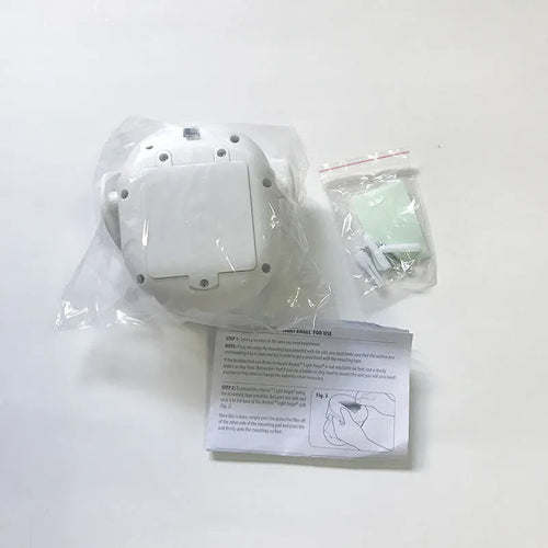 White Atomic Angel induction-activated LED night light on a surface.