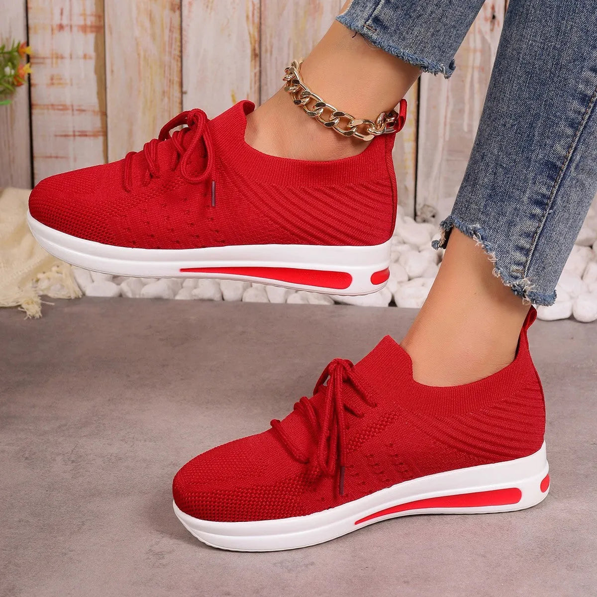 Women's low-top fly-knit sneakers in black, blue, or red with round toe and lace-up front.