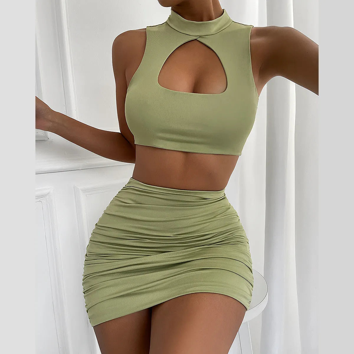 Light purple women's two-piece set with hollow vest and split skirt on a model.