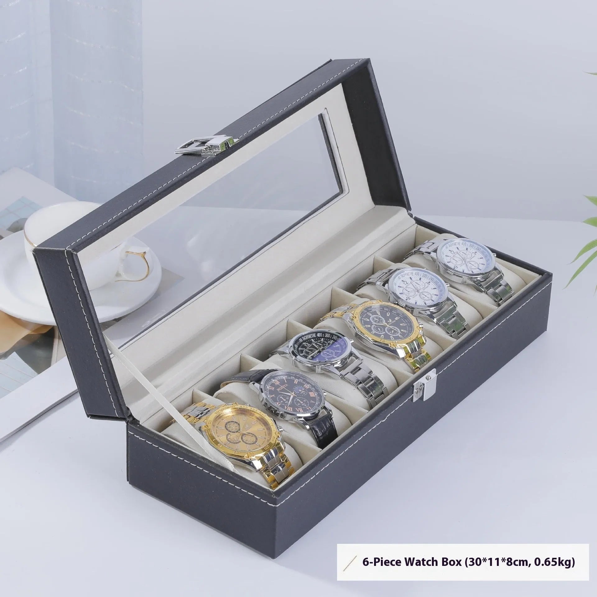 Grey leather watch storage box with transparent lid showing multiple watch slots inside