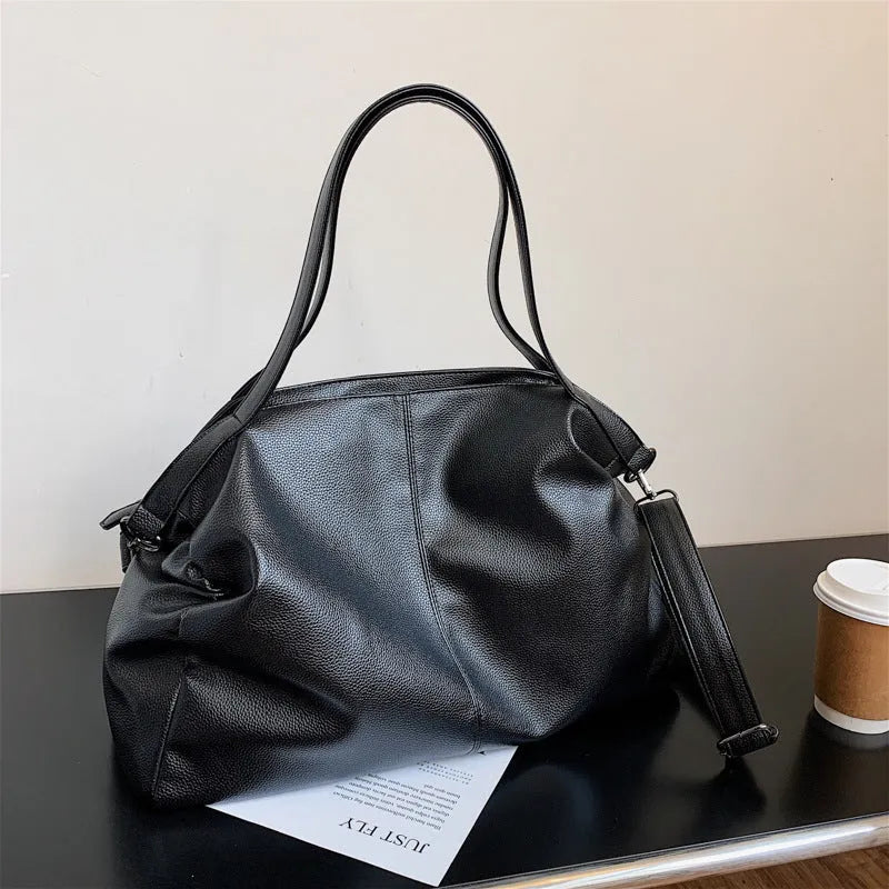 Large soft black PU messenger bag with car suture detail, shown with zip open revealing organiser pockets.