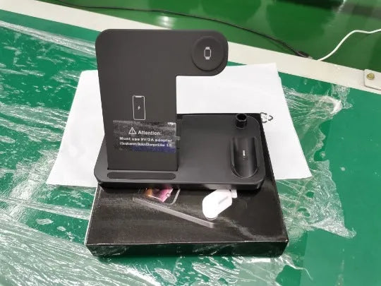 Folding 4-in-1 wireless charger in space grey colour, shown upright as a phone stand with an iPhone charging.