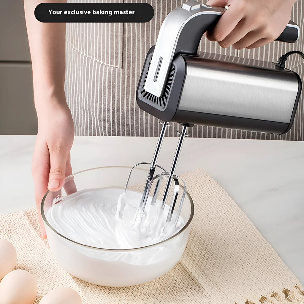 Silver handheld electric kitchen whisk with mixing attachments on counter