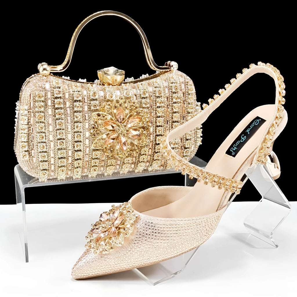 Women's black high heel sandals with ankle chain, floral rhinestone detail, and matching hard clutch bag