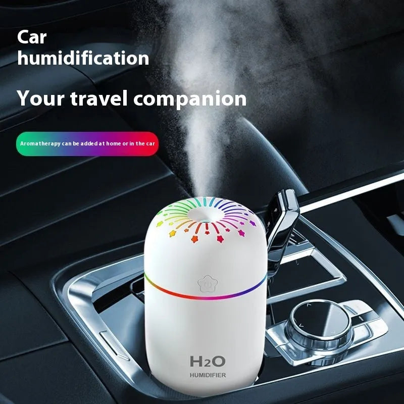 Small white Fireworks USB desktop humidifier with water tank on a wooden desk.