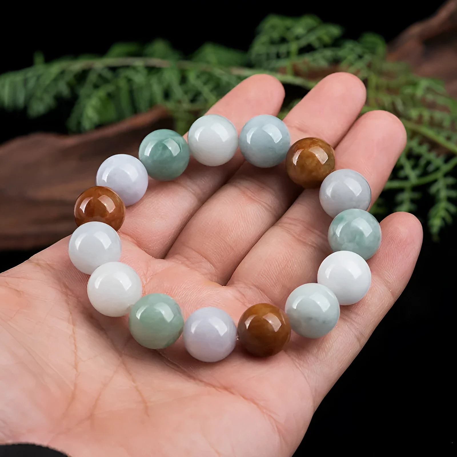 Women's Myanmar jade bracelet showing three-colour pattern on 13mm round beads.