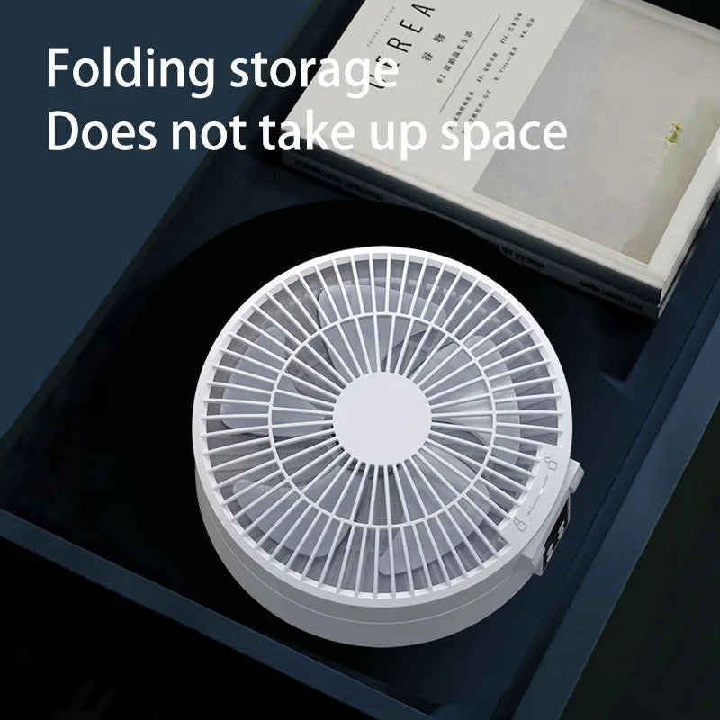 White portable folding desk fan with remote control and warm night light on a table