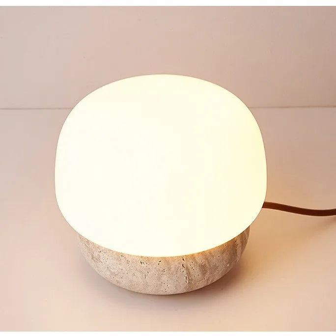 Cream-coloured retro style bedside table lamp with a warm white glow.