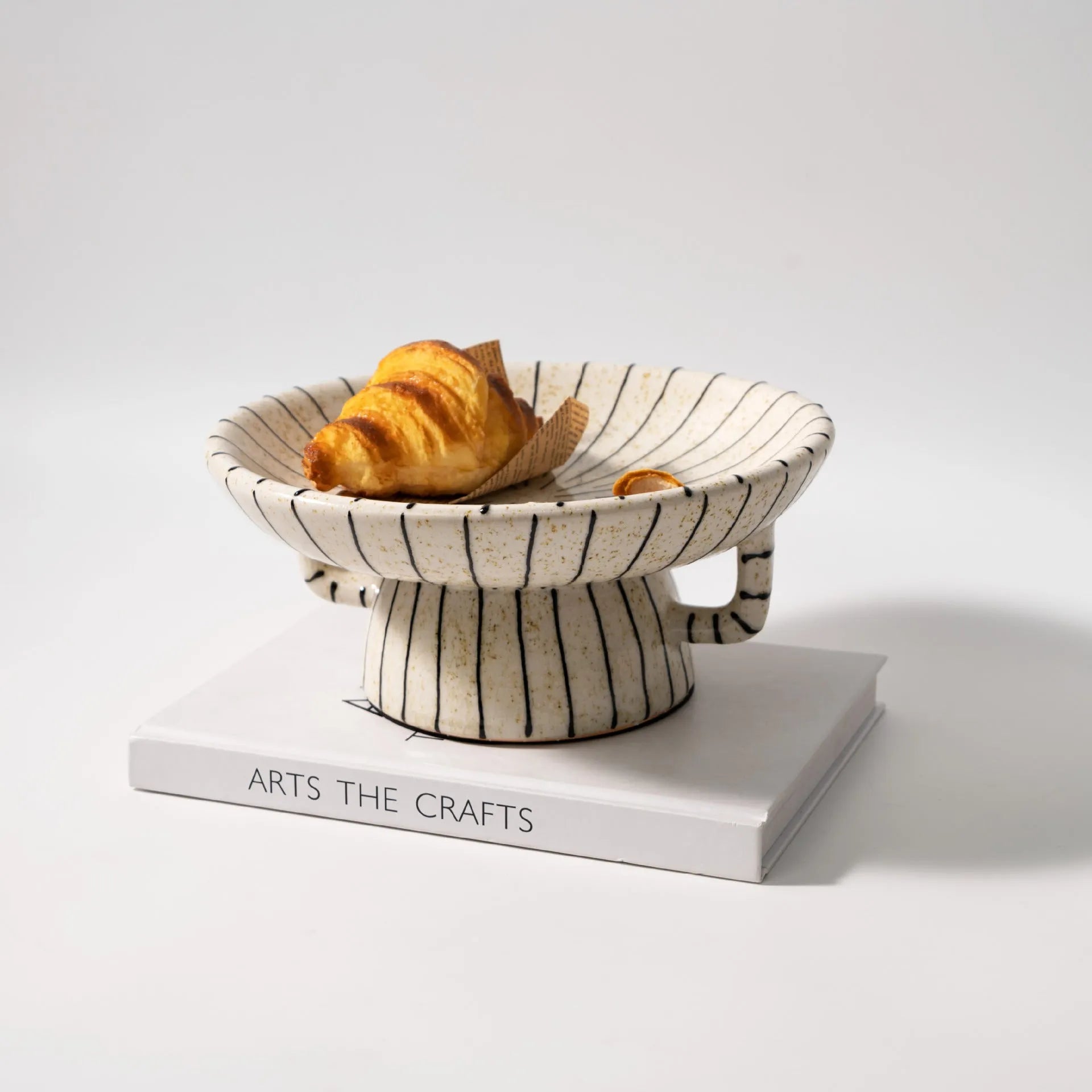 Black and white striped resin fruit plate on a table for dessert serving.