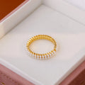 Gold-coloured women's open ring with geometric design and a round pearl-like bead.
