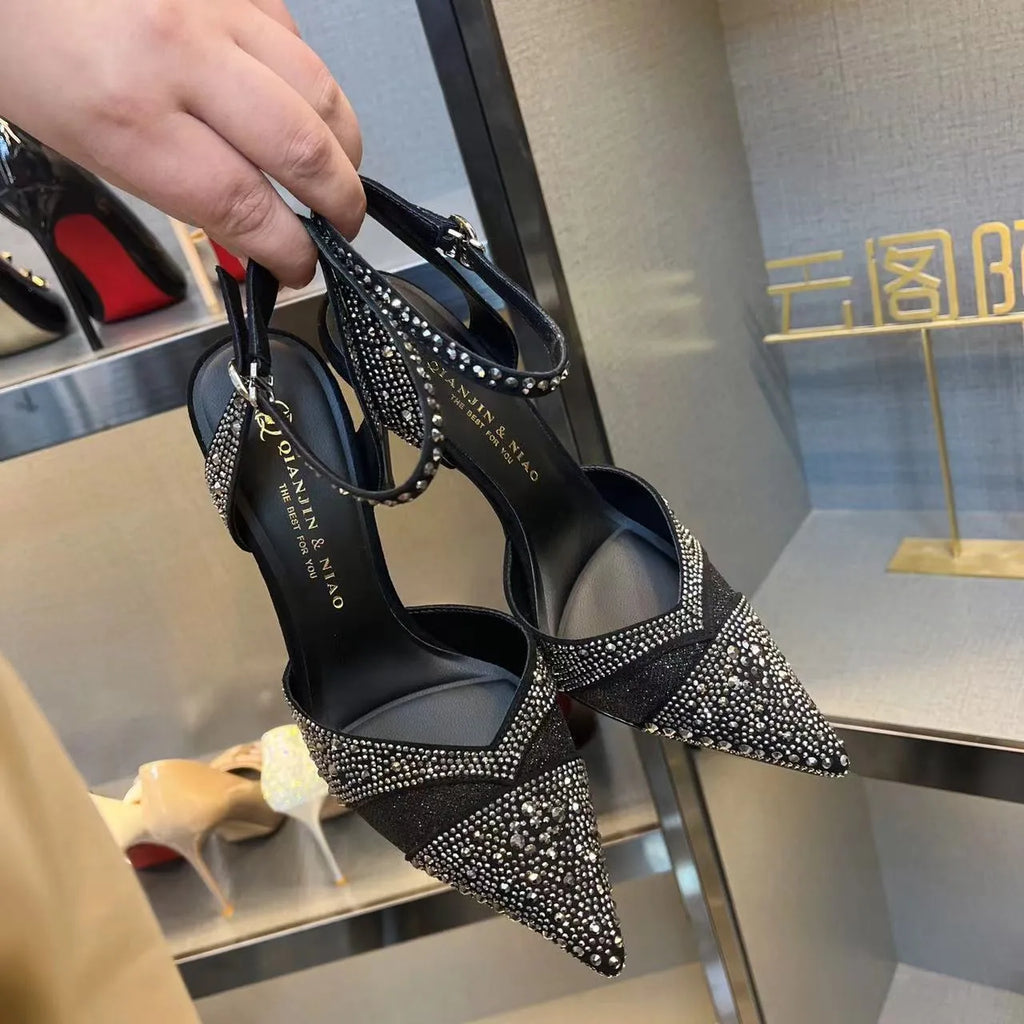Women's black and silver hollow high heels with red stiletto soles and pointed toes.