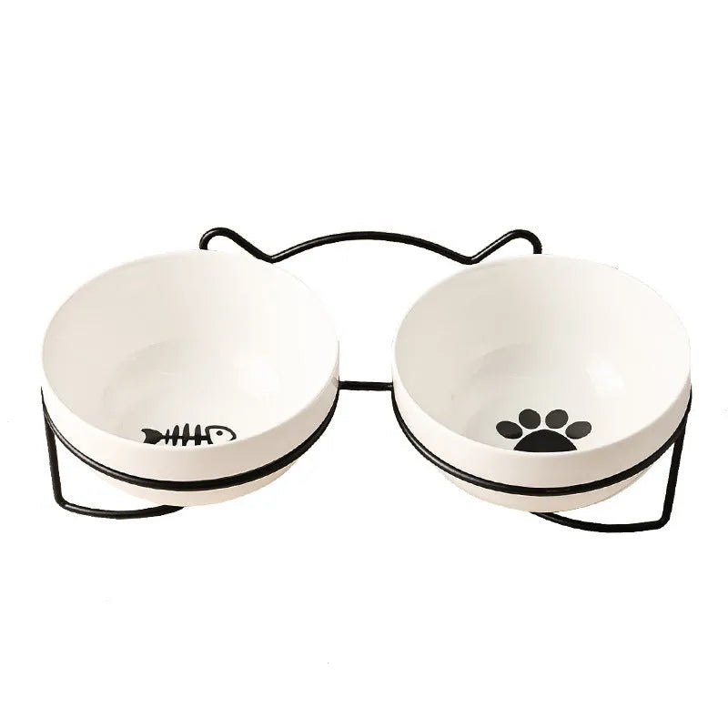 White ceramic pet bowl with cat paw print design on a black iron frame stand with cat ear details.