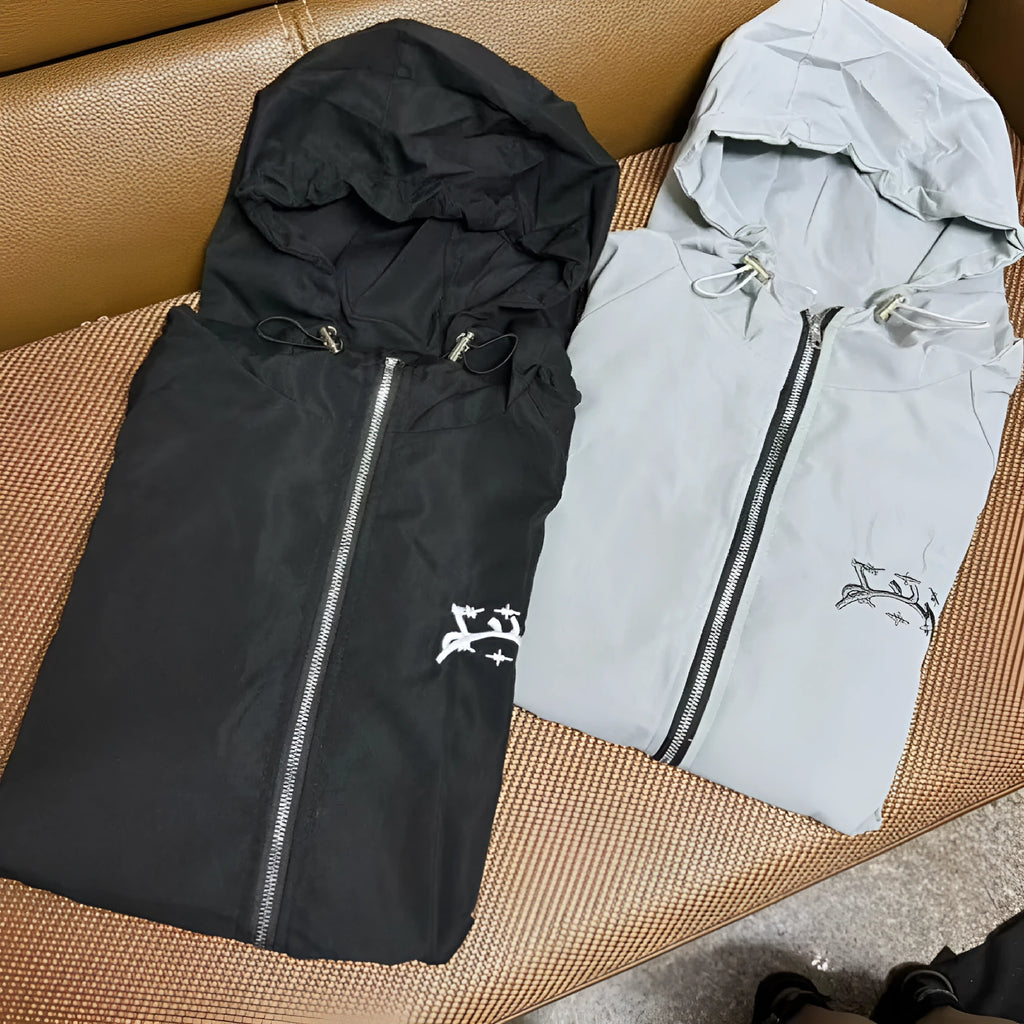 A grey men's hooded loose-fit sunscreen jacket on a hanger, showcasing its British-style design.