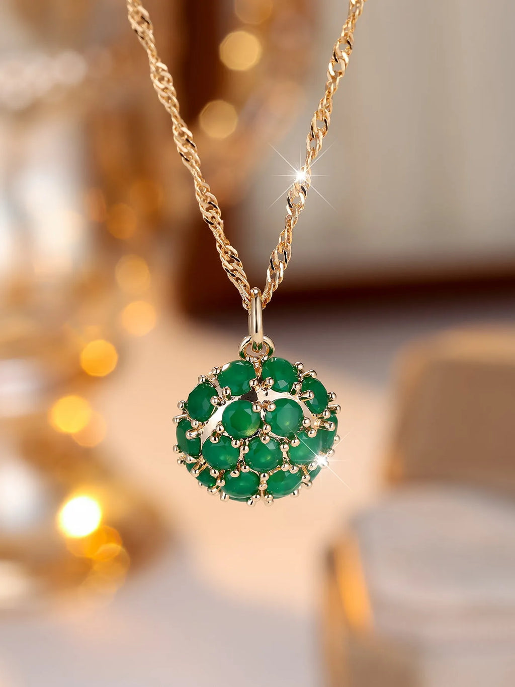 Women's champagne gold necklace with round emerald pendant and diamond accents on copper chain