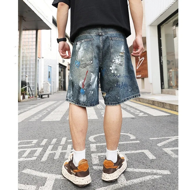 Blue ripped men's denim shorts with graffiti print and a zipper fly