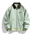 Man wearing a mint green loose-fit retro workwear jacket with contrast lapels and side pockets.