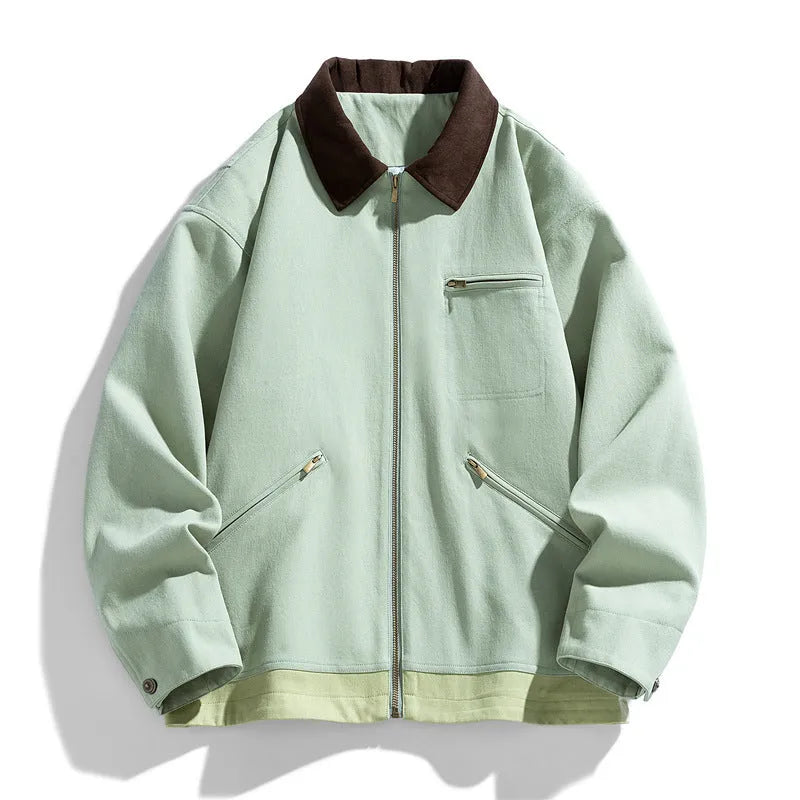 Man wearing a mint green loose-fit retro workwear jacket with contrast lapels and side pockets.