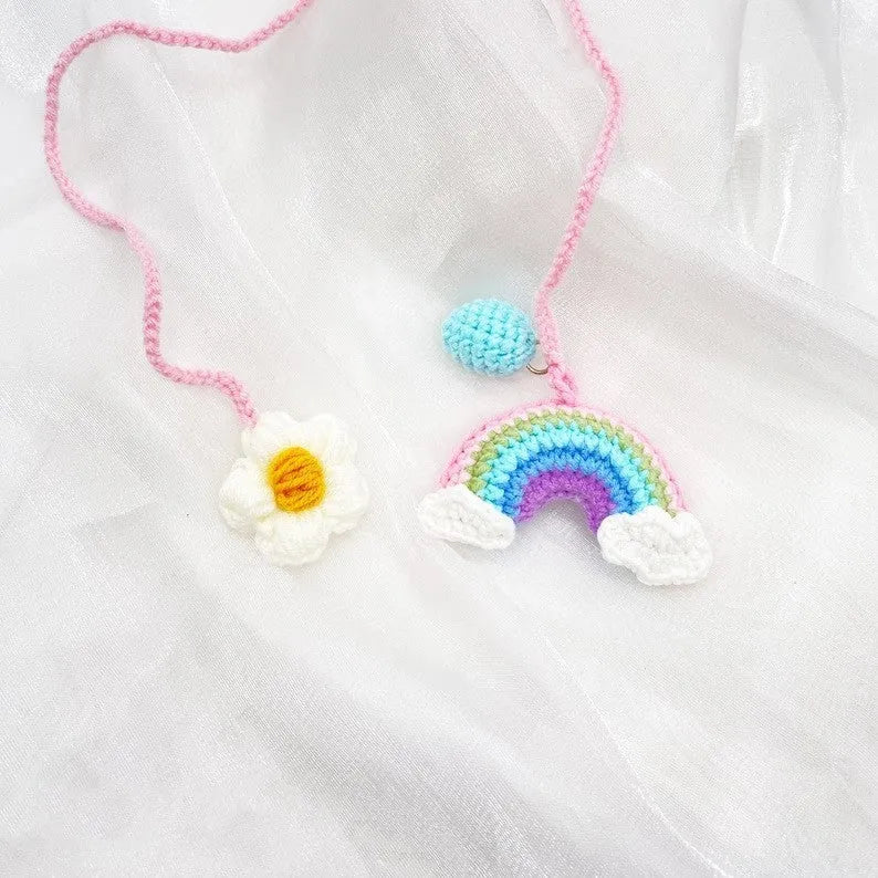 Handmade crocheted car pendant with avocado and rainbow colours hanging from rear-view mirror