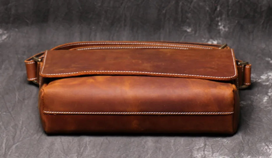 Brown vintage leather men's messenger bag with a flap opening and an adjustable shoulder strap.
