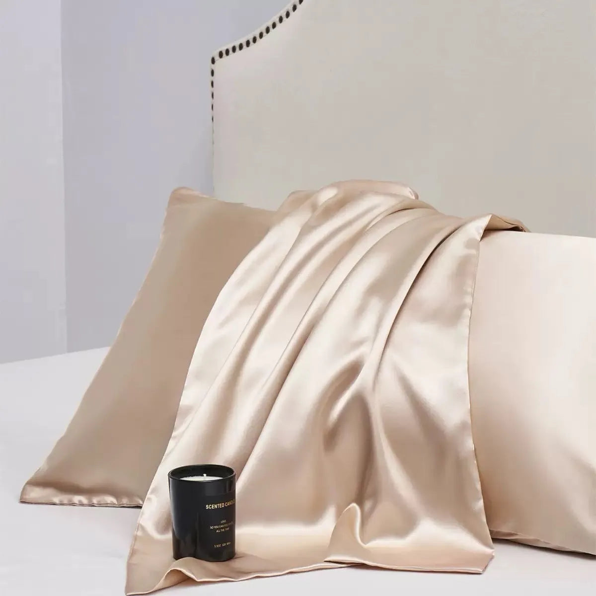 A pair of solid colour satin pillowcases in various colours and sizes on a bed.