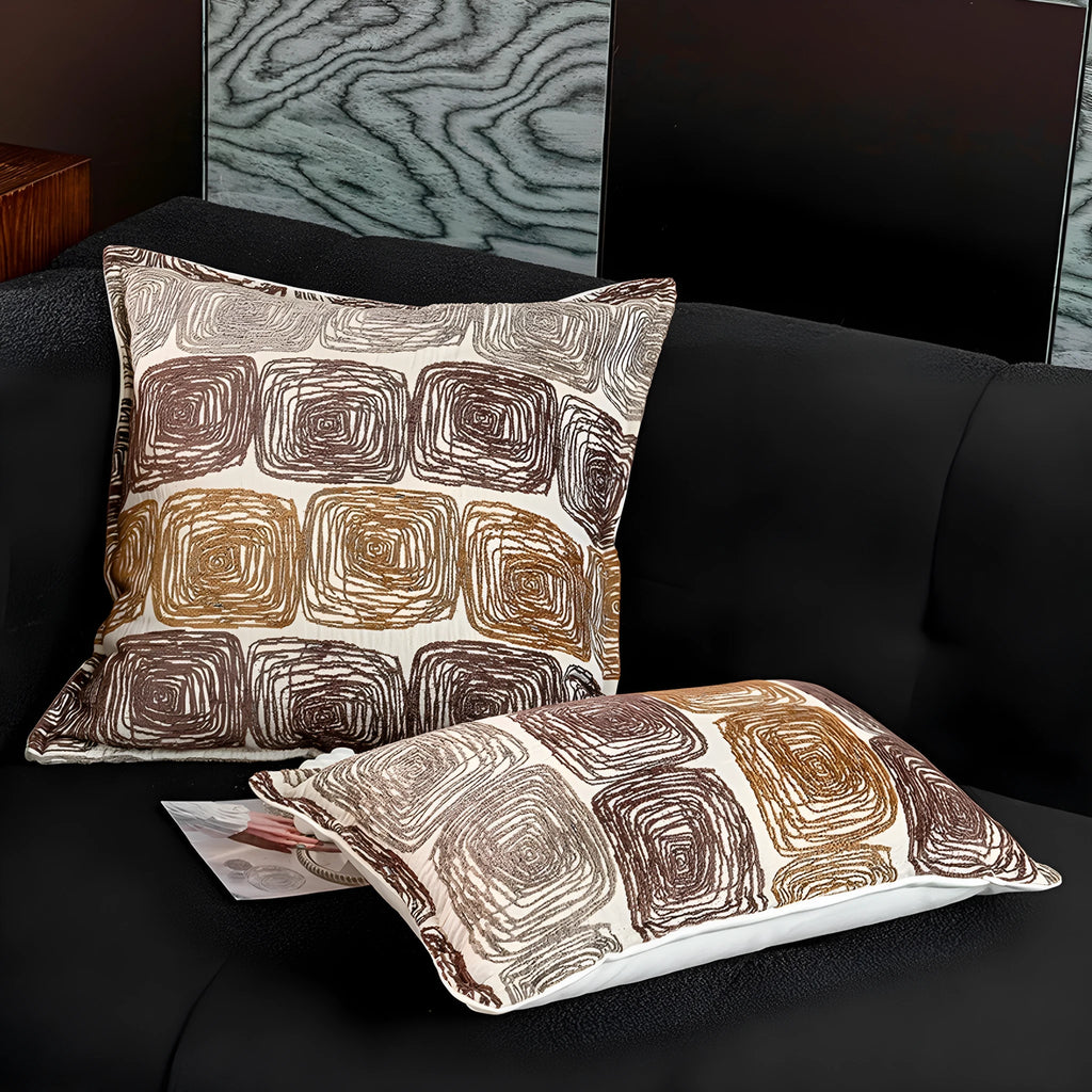Abstract geometric coil pattern pillow cover in cream and coffee colours on textured fabric