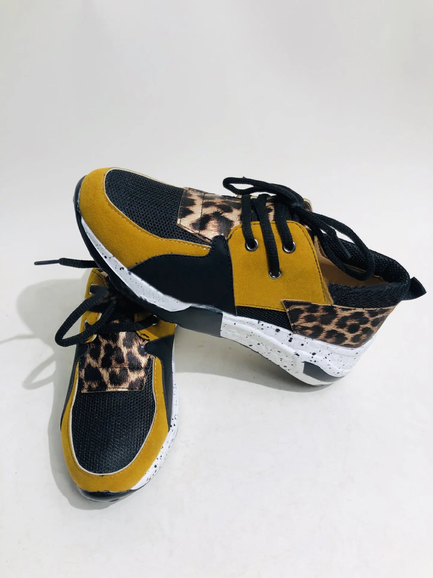 Women's casual suede sneakers with a wedge heel in various colours including black, pink, and leopard print.