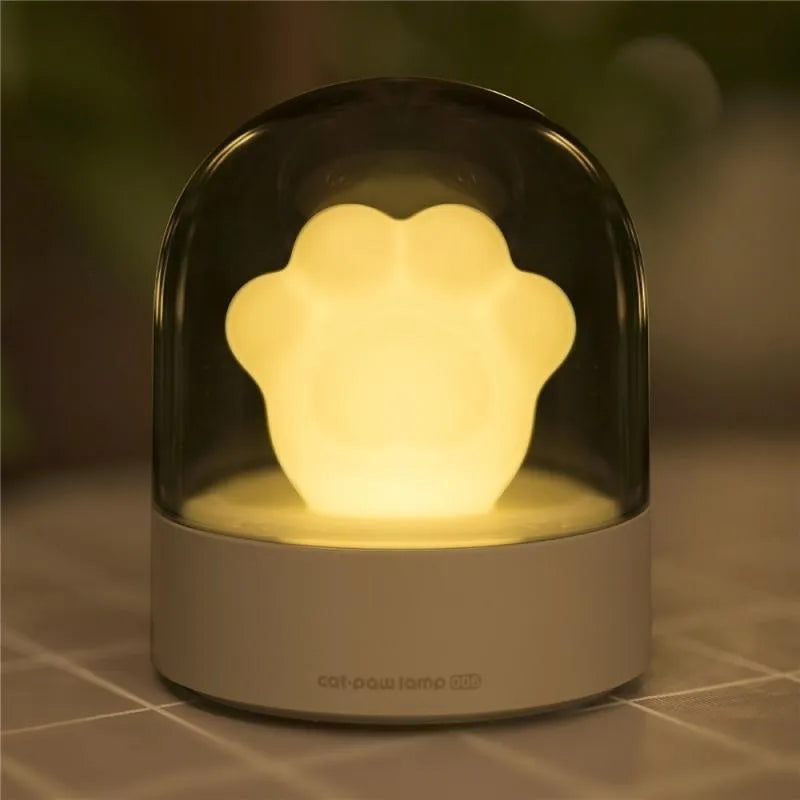 Grey and pink cat paw shaped USB rechargeable night light with adjustable brightness and musical rotation features