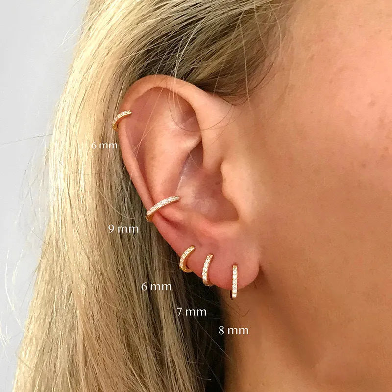 Gold, rose gold, and silver coloured circle-shaped zircon stud earrings on a white background.