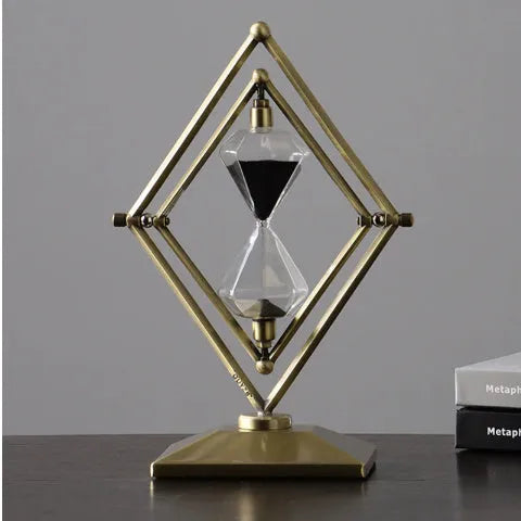 Glass sand clock with metal base showing coloured sand, in bronze or silver finish options.