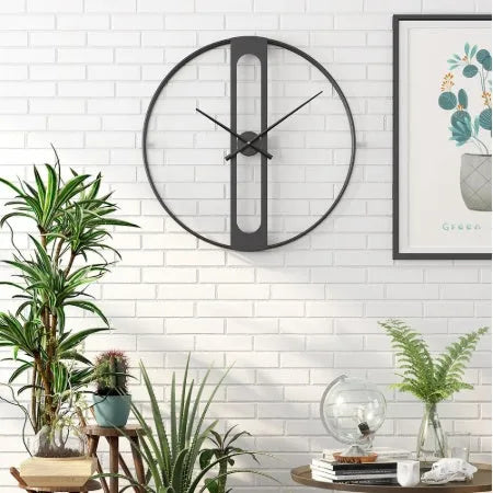 A large 50cm round metal wall clock on a wall, shown in black and gold colour variants.