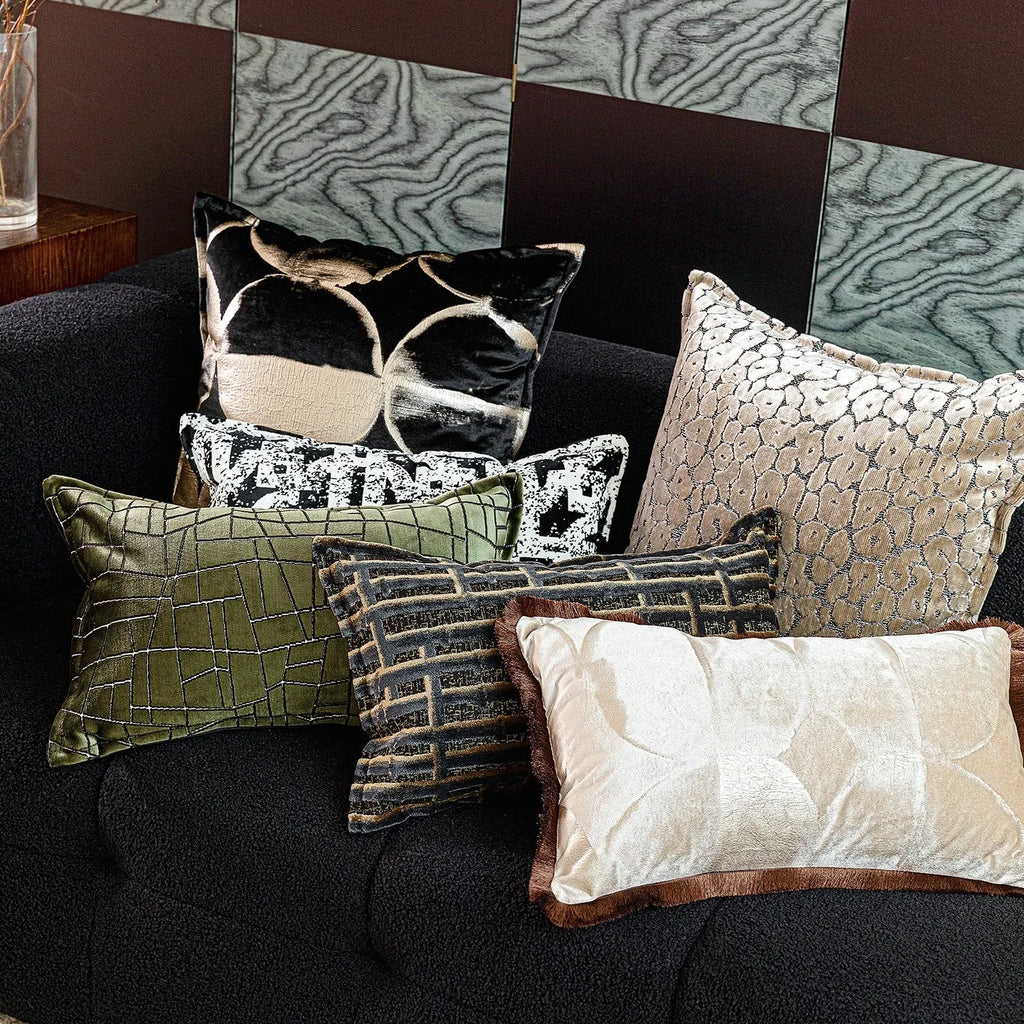 Black and gold abstract patterned flannel sofa cushion with removable cover on a grey sofa.