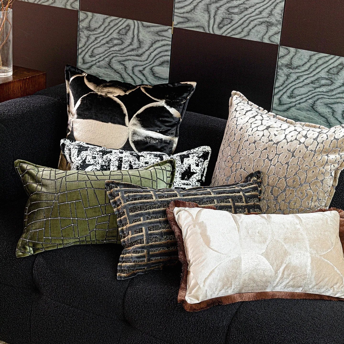 Black and gold abstract patterned flannel sofa cushion with removable cover on a grey sofa.
