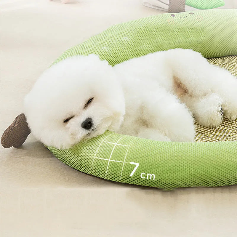 Green pet cooling mat with a raised fruit-shaped backrest, shown with a dog resting on it.
