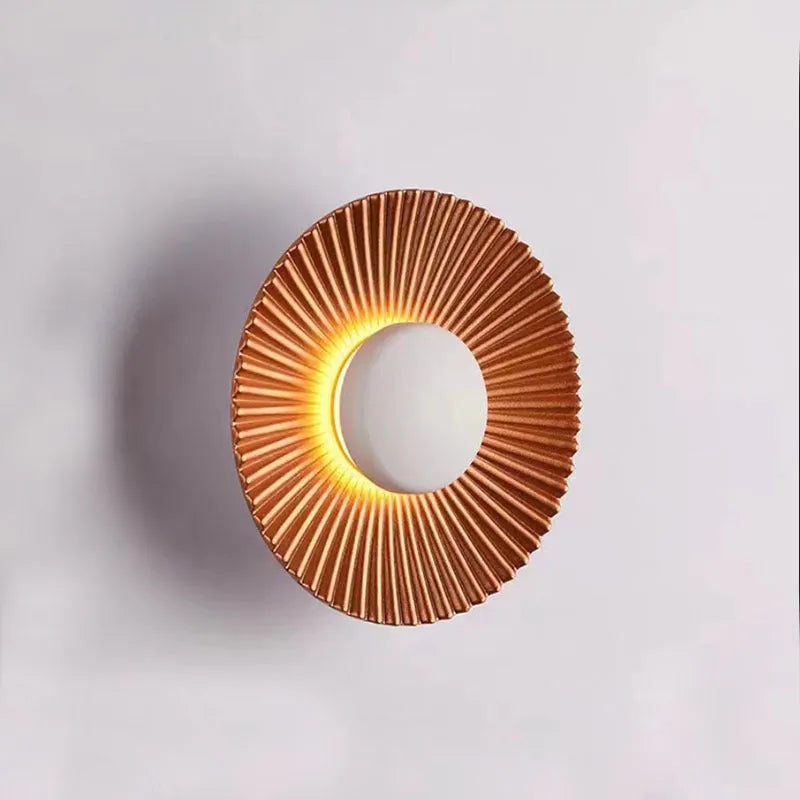 Round aluminium wall lamp with outer white and inner gold finish mounted on a wall
