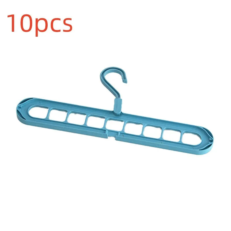 Green plastic multifunctional hanger with nine arms for folding trousers, shown hanging on a rail.